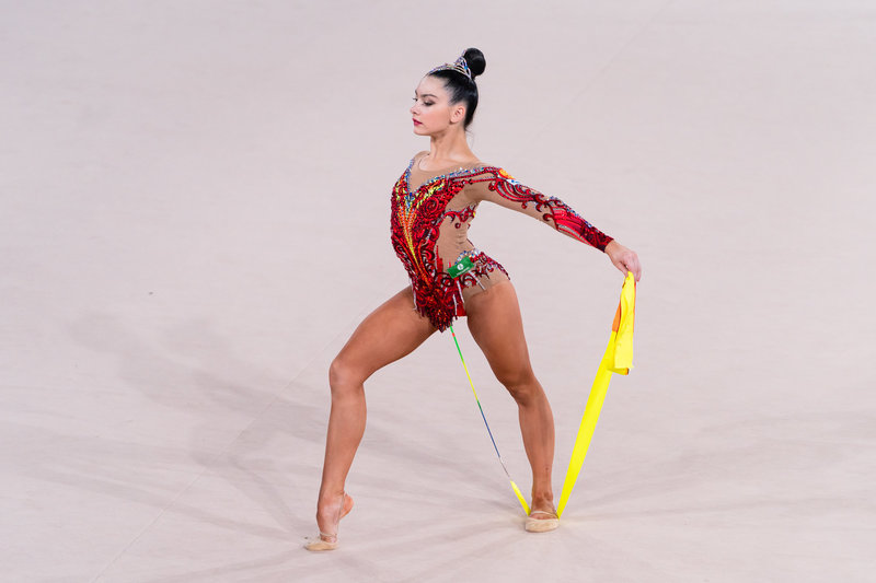 Гибкая гимнастка с короткой стрижкой снимает прозрачное одеяние